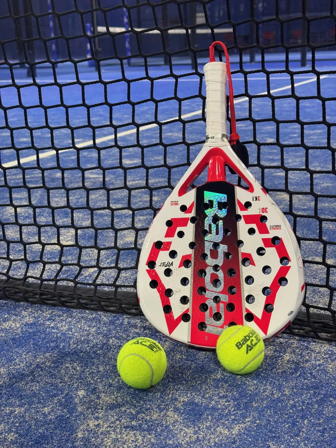 Racket en ballen klaar tegen het net, voor aanvang van een potje