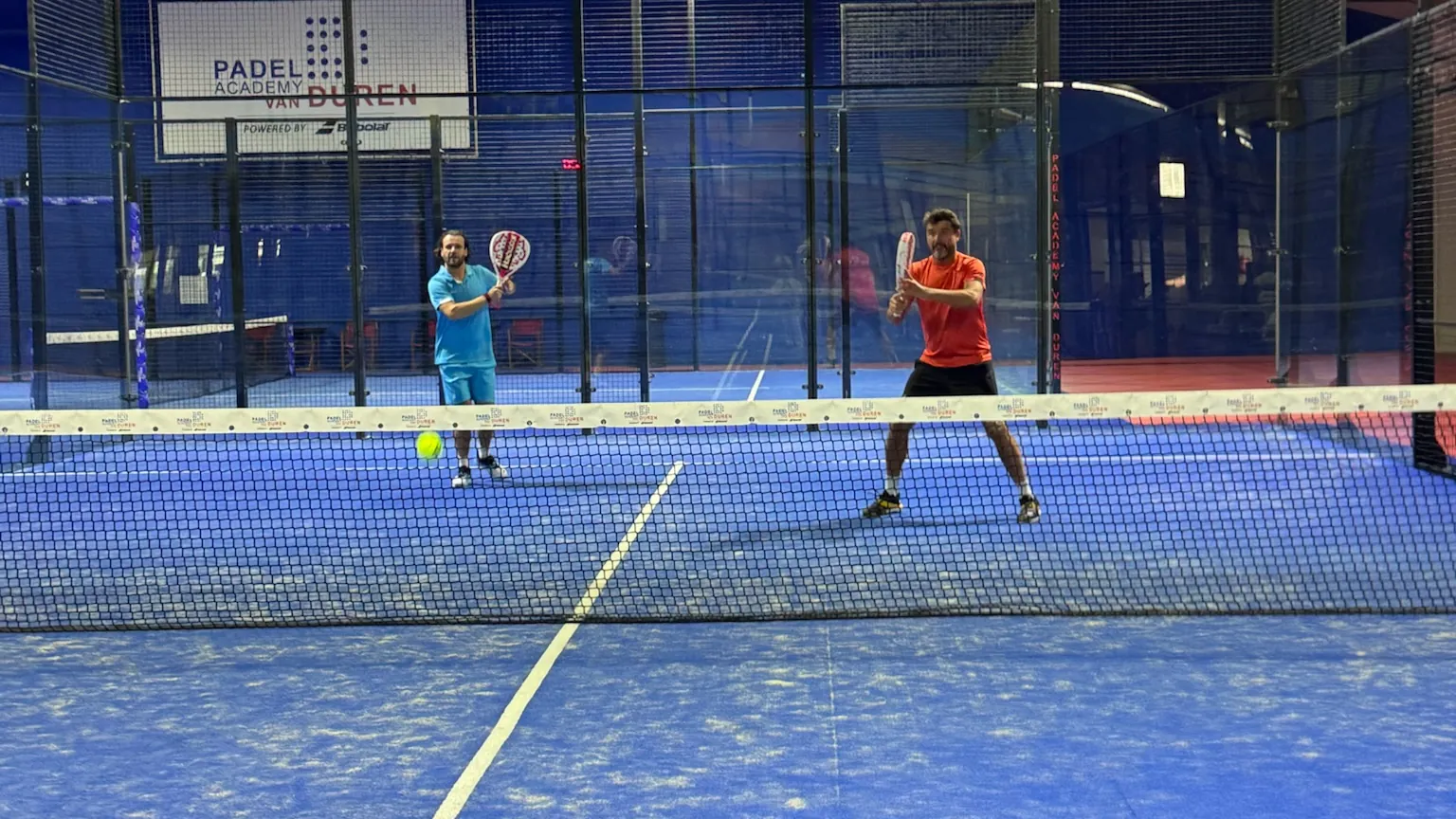 Twee spelers in actie op een van de indoor banen