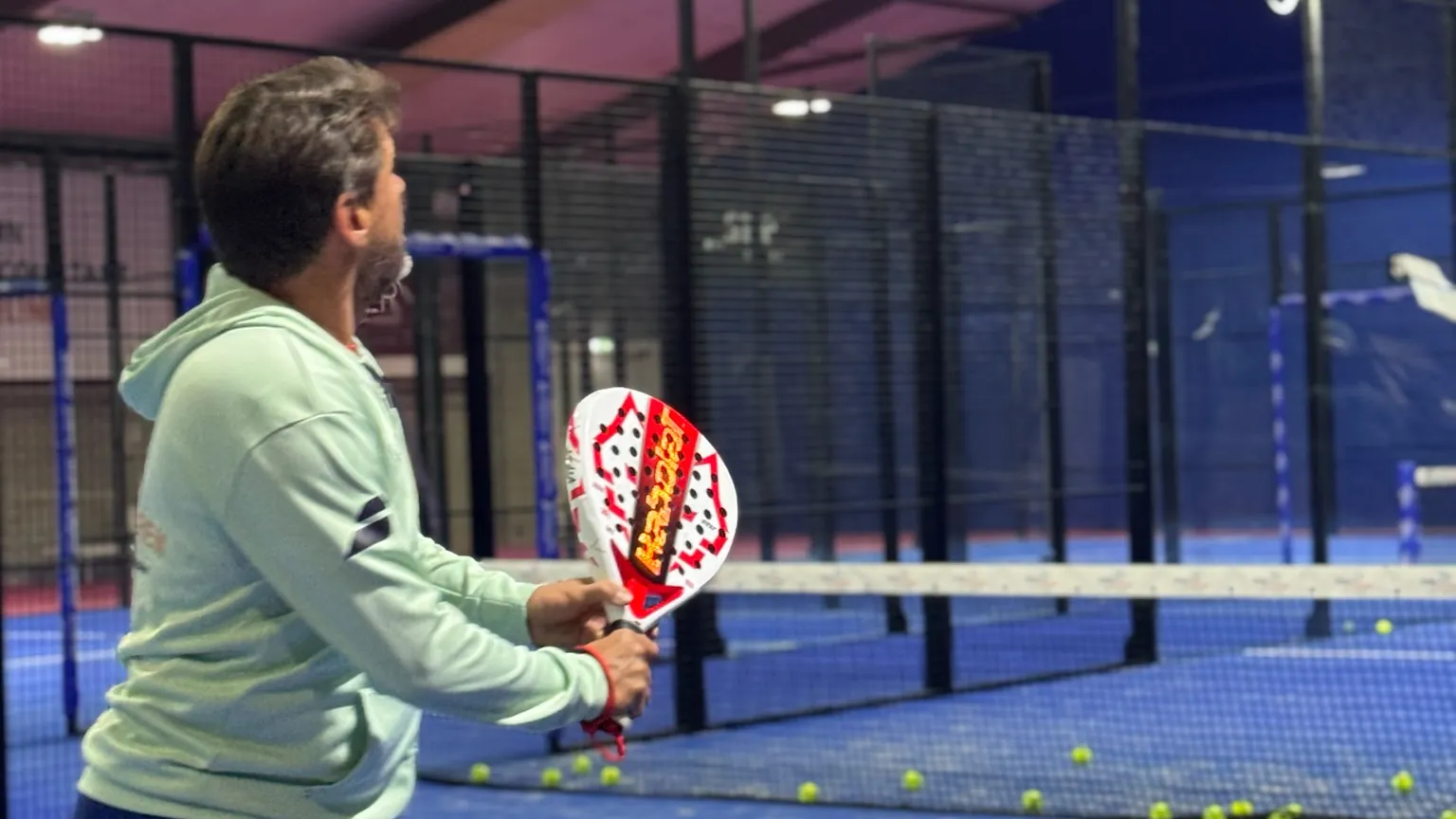 Trainer van Van Duren met racket aan het net